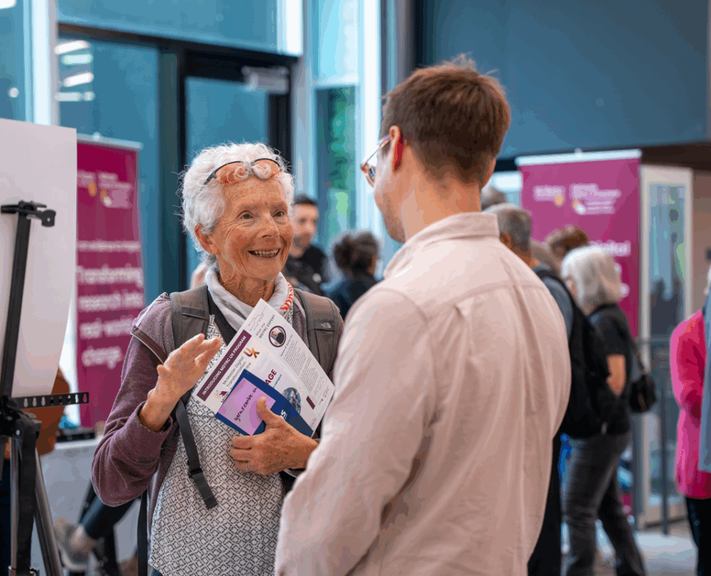 Mac engAGE attendee conversing with researcher