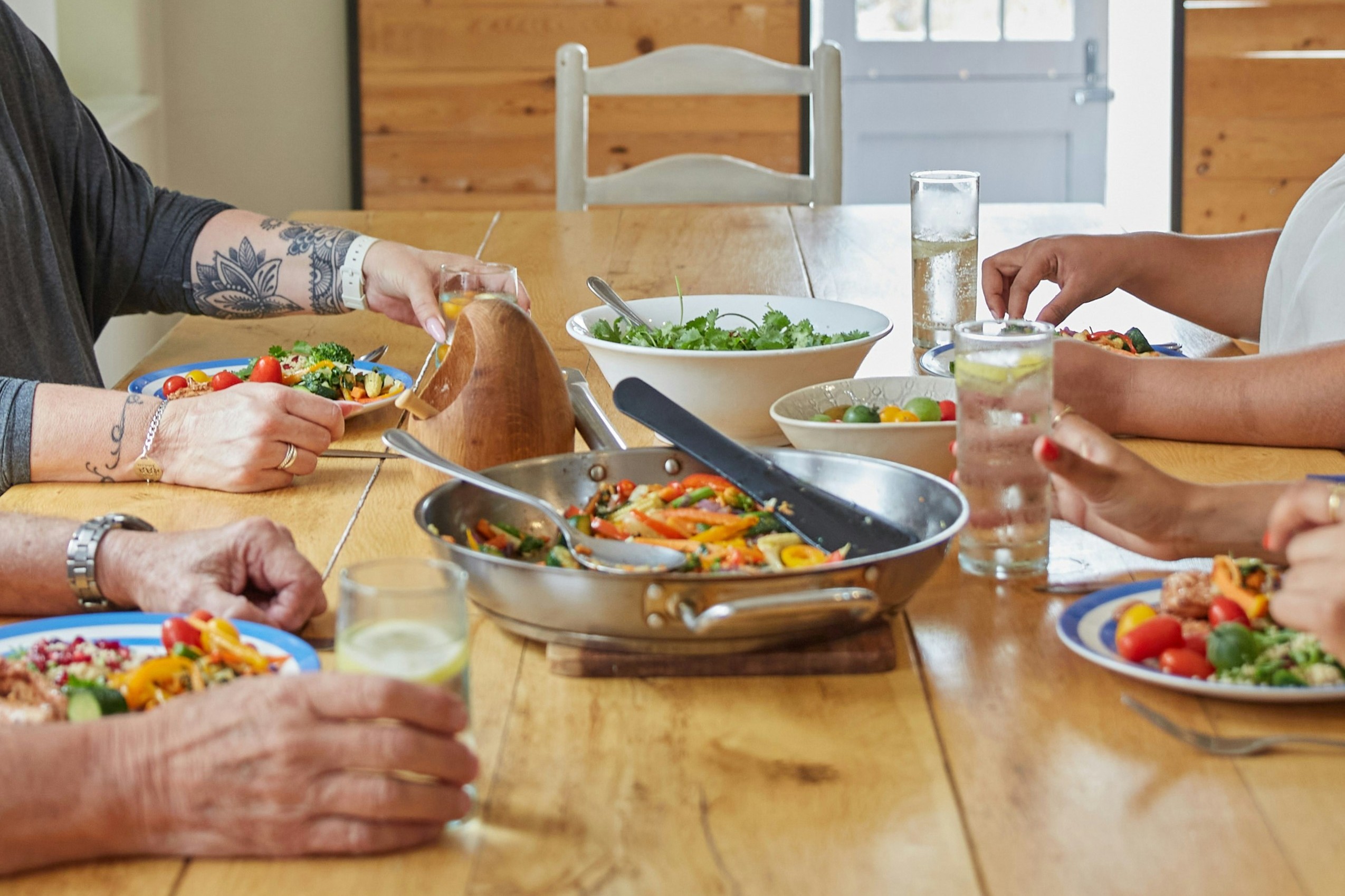 close-up on a table with colourful food and people eating