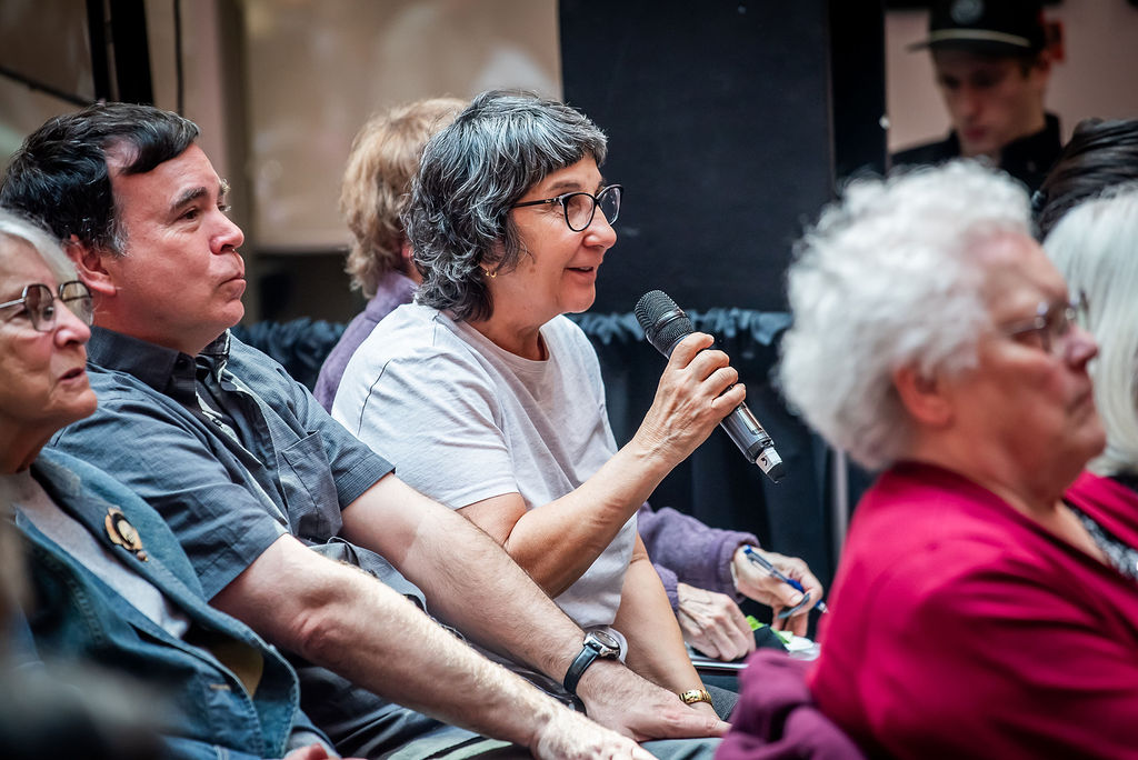 A community member asks a question in the audience of a talk