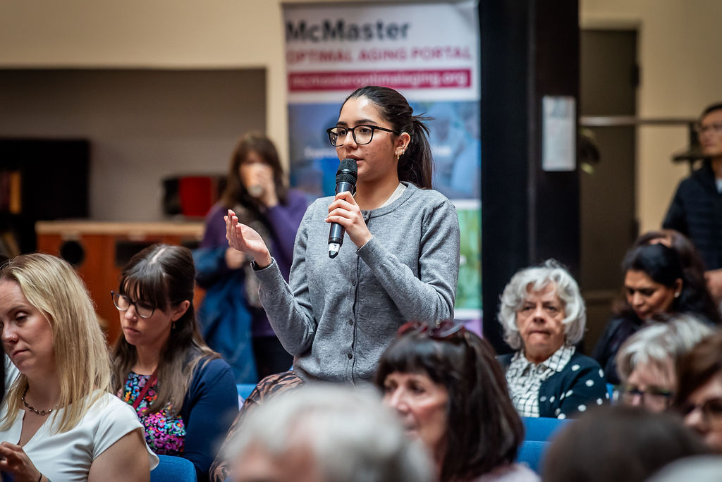 An audience member asks a question on a microphone